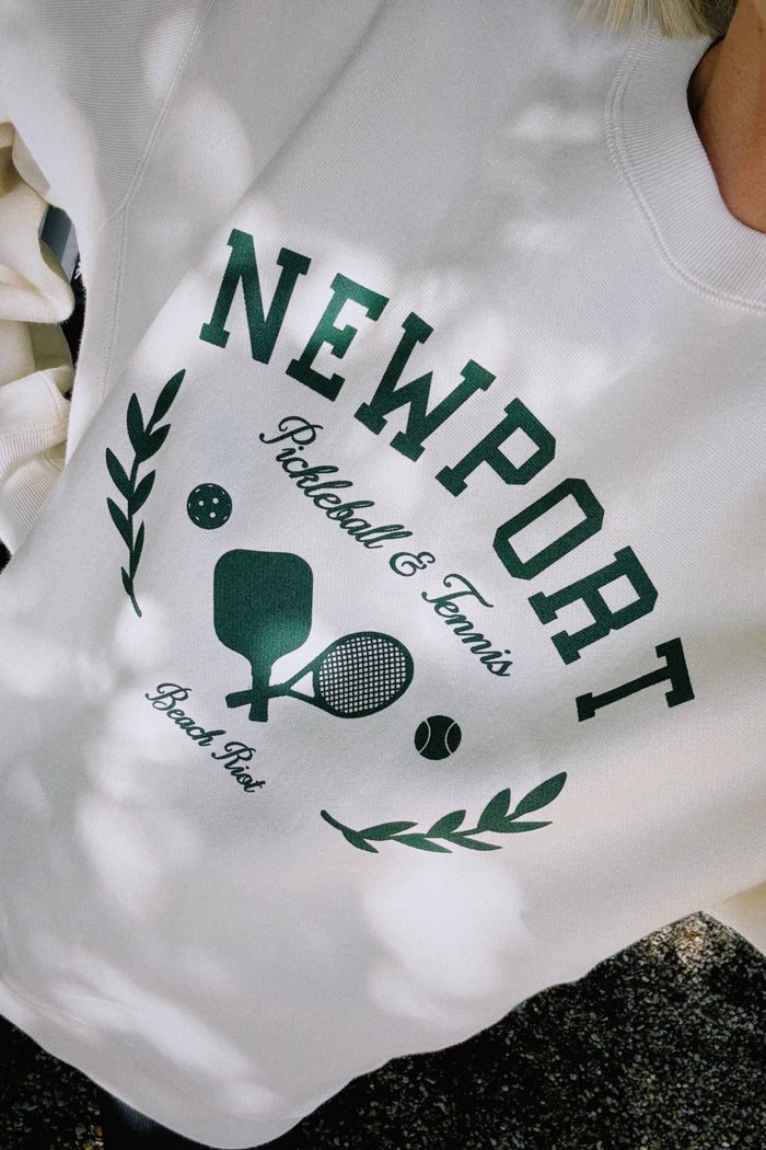 White sleeveless top with green text and graphics on a blurred background