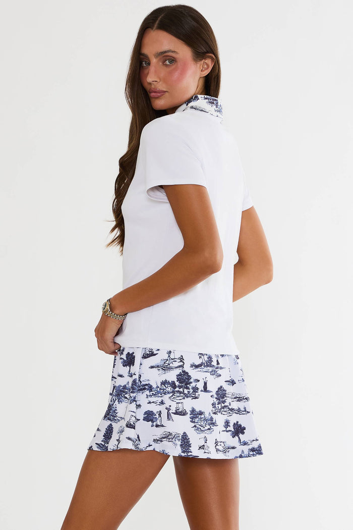 Woman wearing a white top and blue patterned skirt on a white background