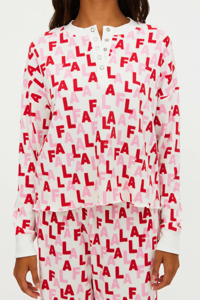 White pajama top with red and pink 'FLA' pattern worn by a person.