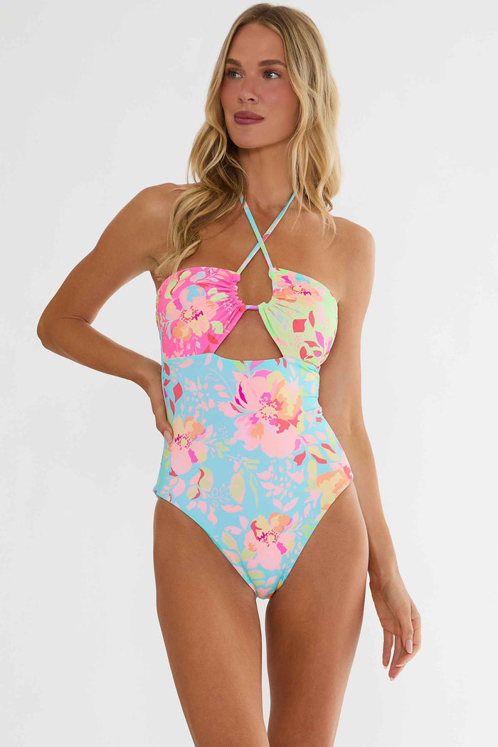Woman wearing a colorful floral swimsuit on a white background