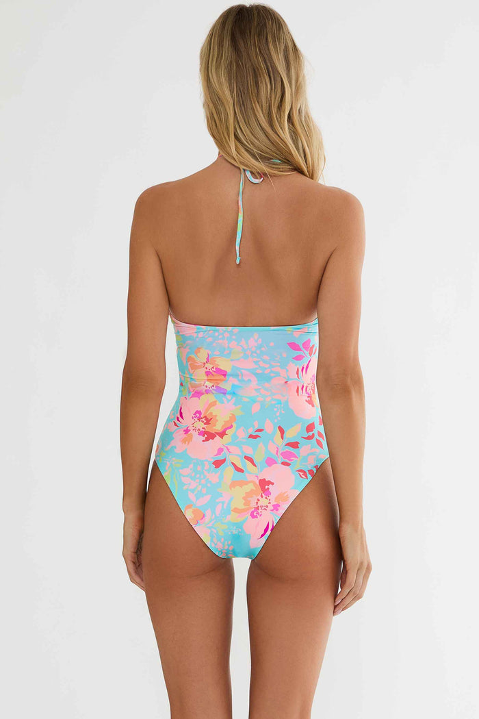 Woman wearing a floral high-waisted swimsuit on a white background