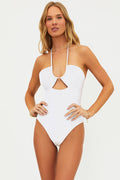 Woman wearing a white halter neck swimsuit on a plain background