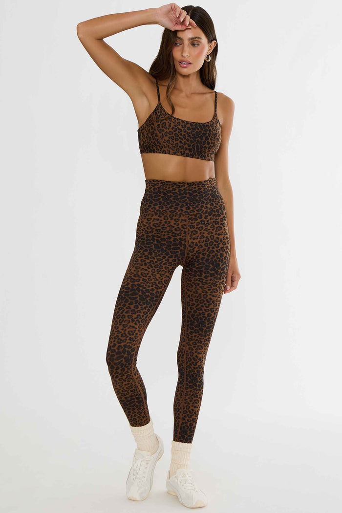 Woman wearing brown and black leopard leggings.