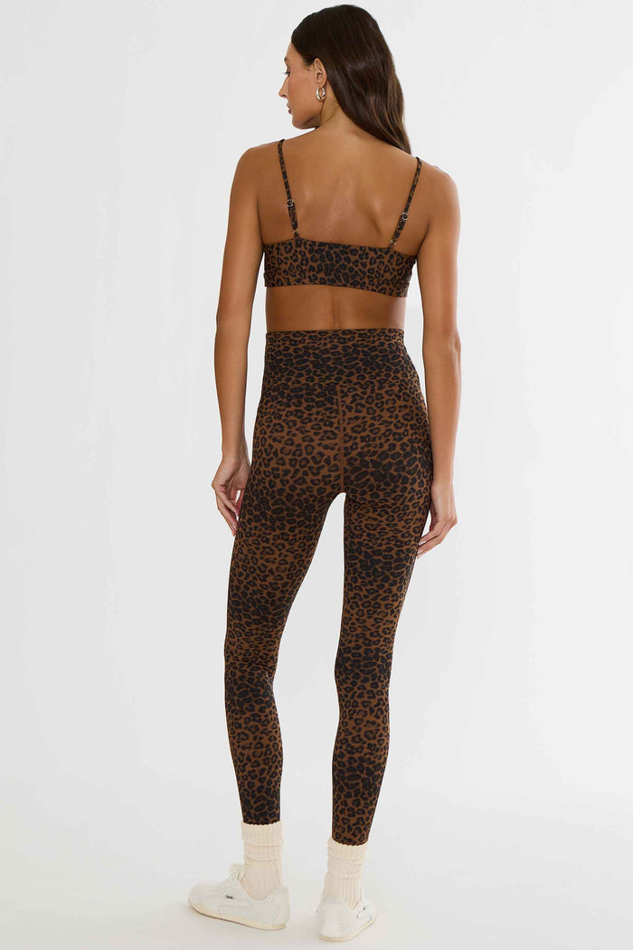 Woman wearing brown and black leopard leggings.