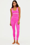 Woman wearing a bright pink athletic outfit on a white background