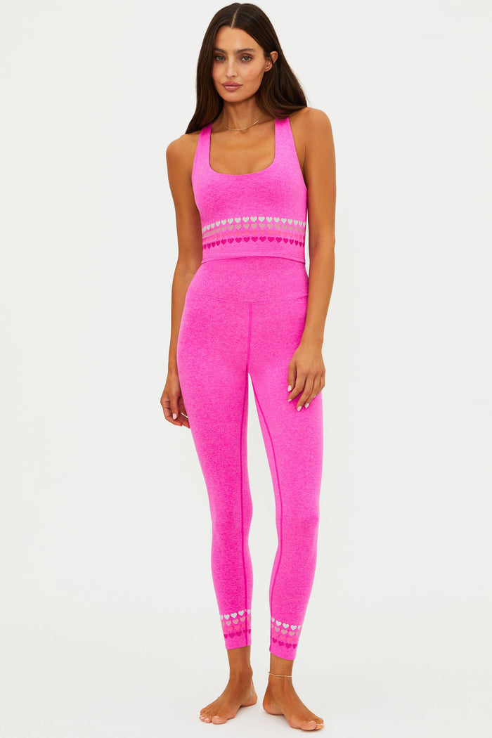 Woman wearing a bright pink athletic outfit on a white background