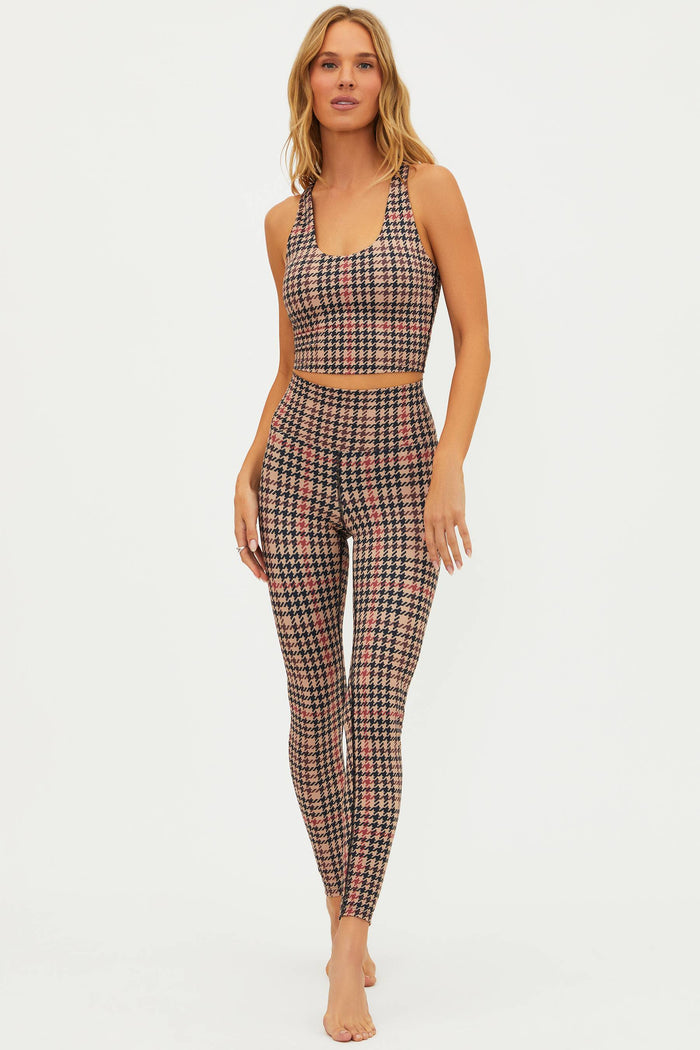 Woman wearing a plaid sports bra and leggings set on a white background
