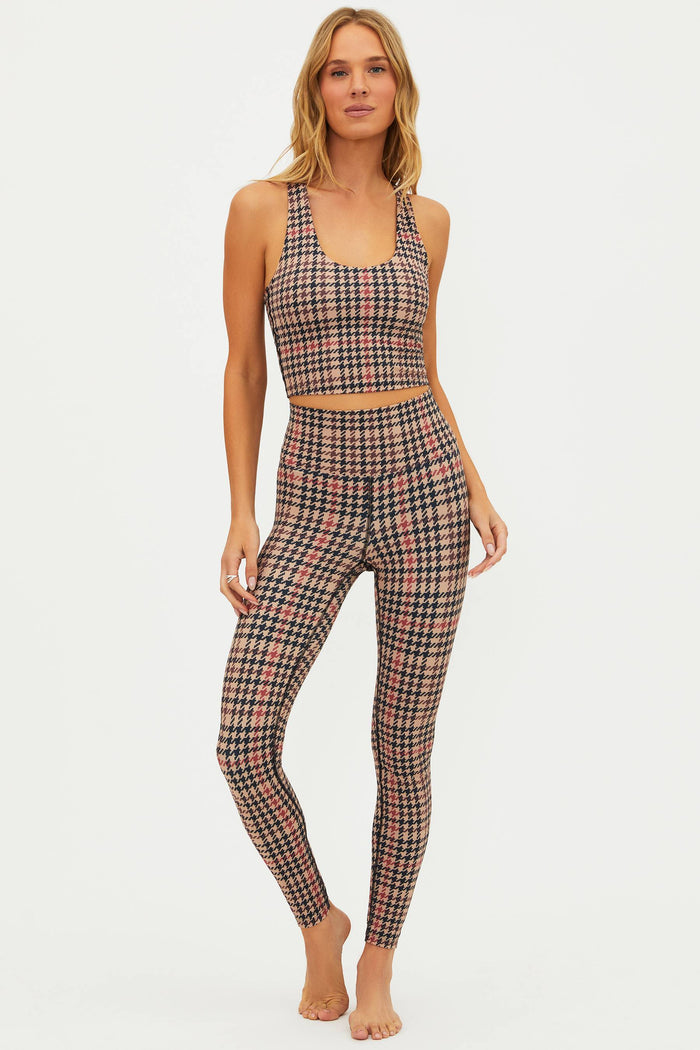 Woman wearing a plaid sports bra and leggings set on a white background