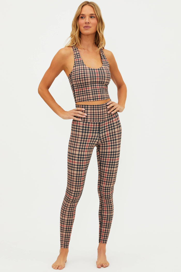 Woman wearing a plaid sports bra and leggings set on a white background