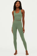 Woman wearing a green athletic outfit on a white background
