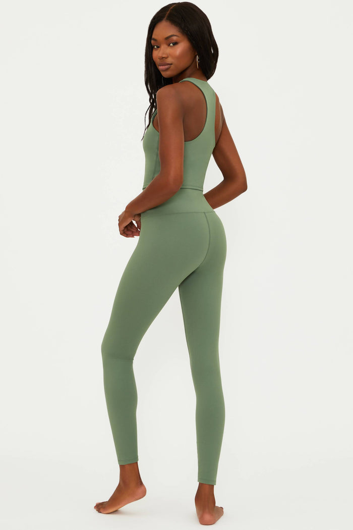 Woman wearing a green athletic outfit on a white background