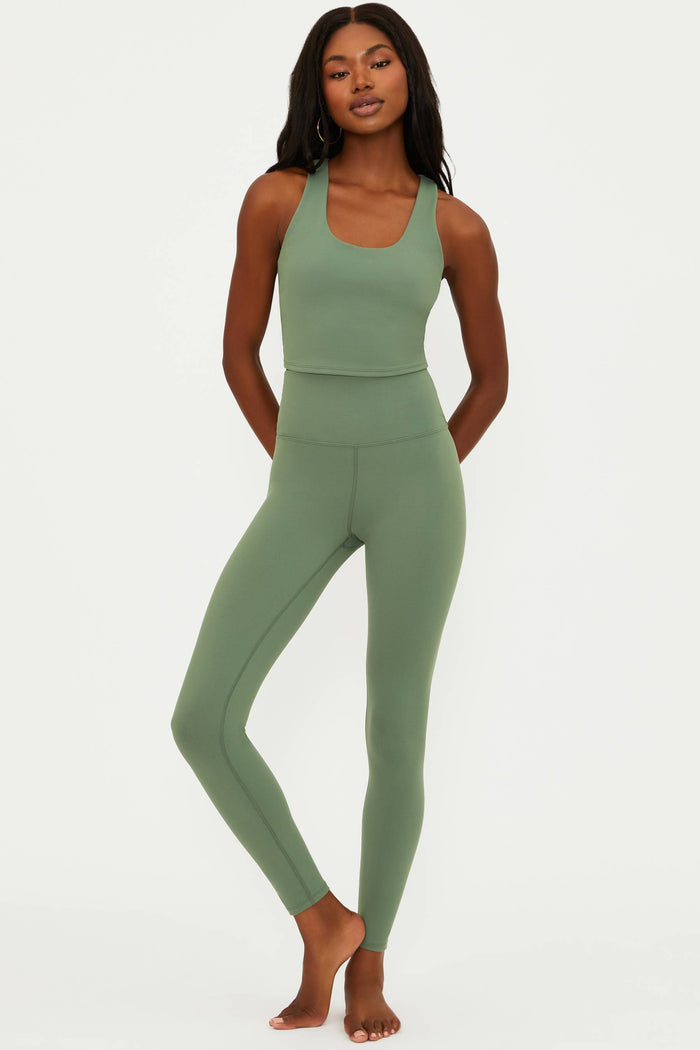 Woman wearing a green athletic outfit on a white background