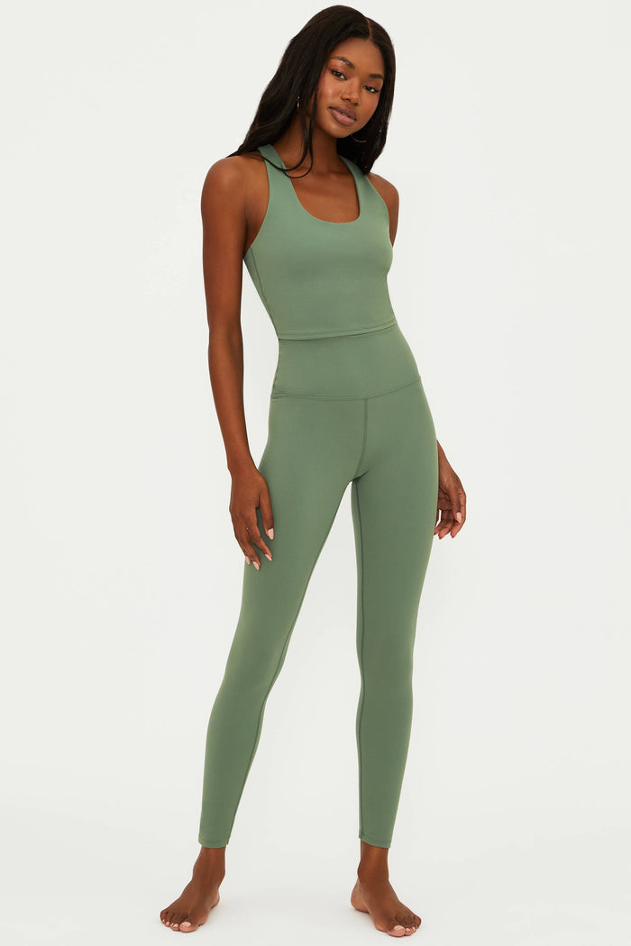 Woman wearing a green athletic outfit on a white background