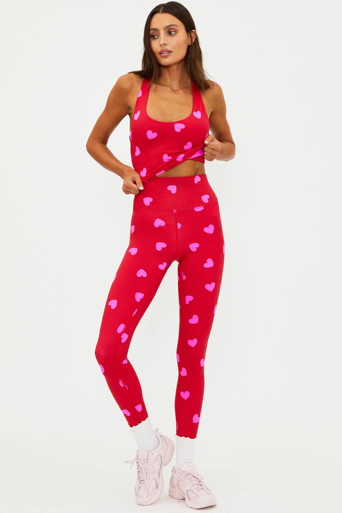 Woman wearing a red heart-patterned athletic outfit on a white background