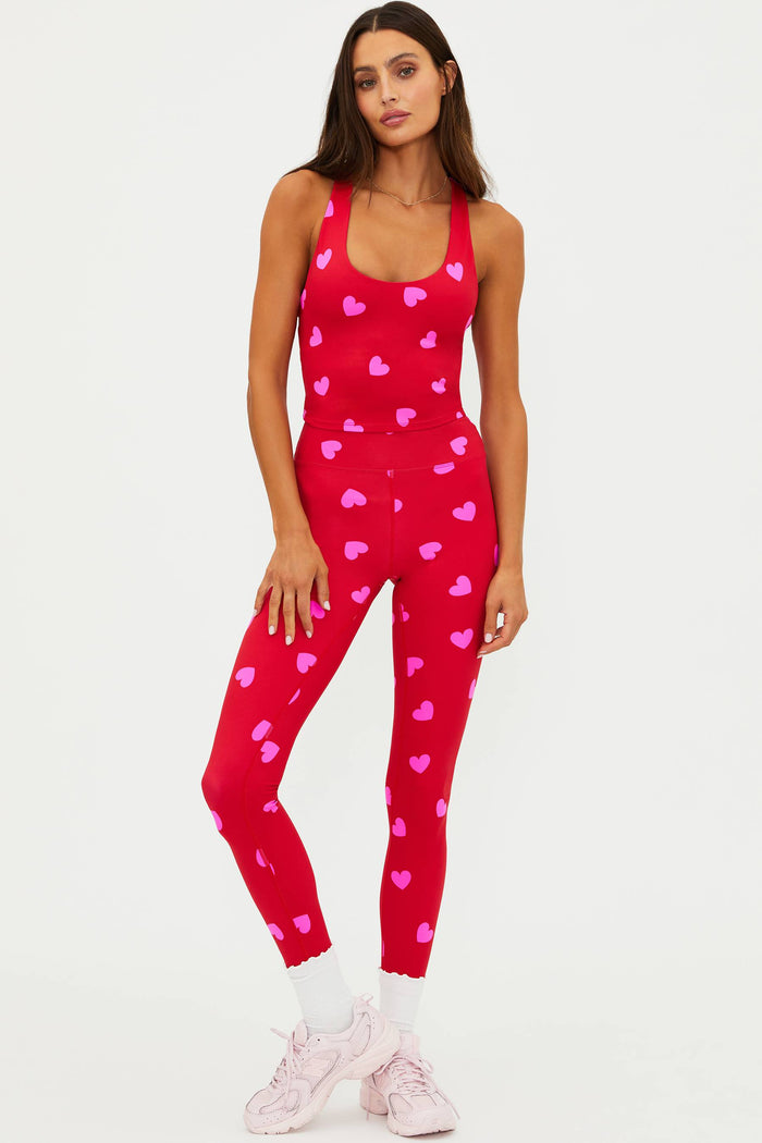 Woman wearing a red outfit with pink heart patterns on a white background