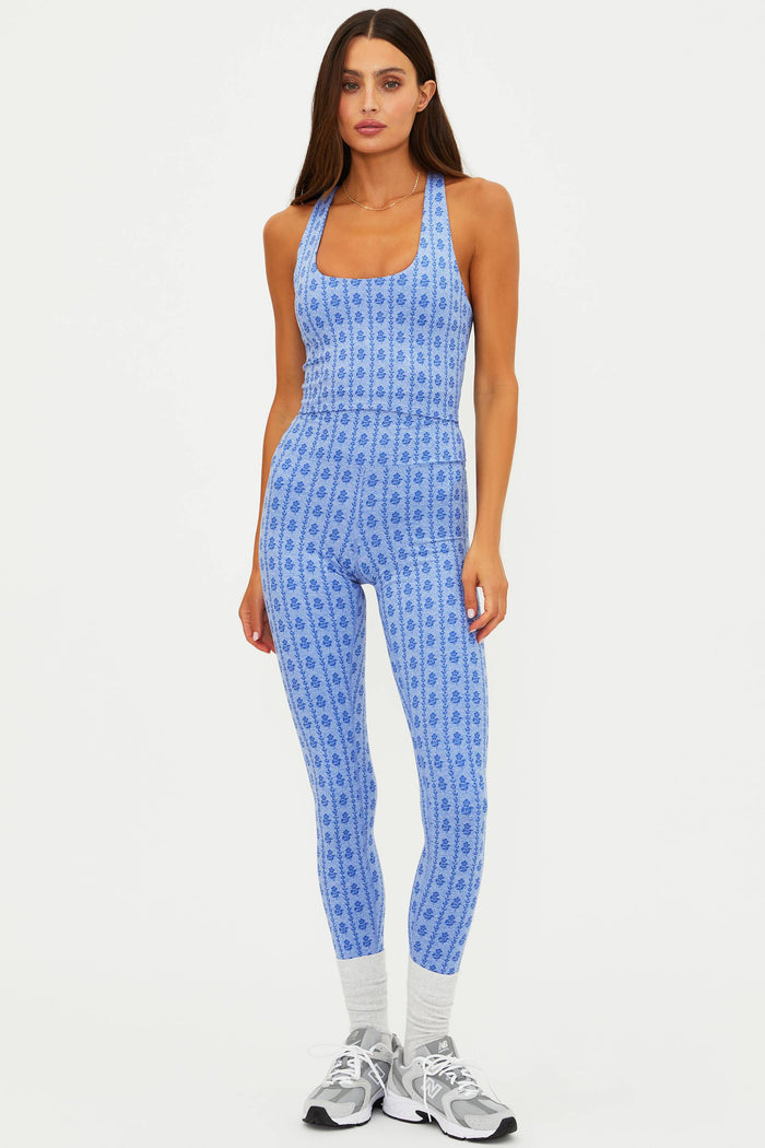 Woman wearing a blue patterned jumpsuit on a white background