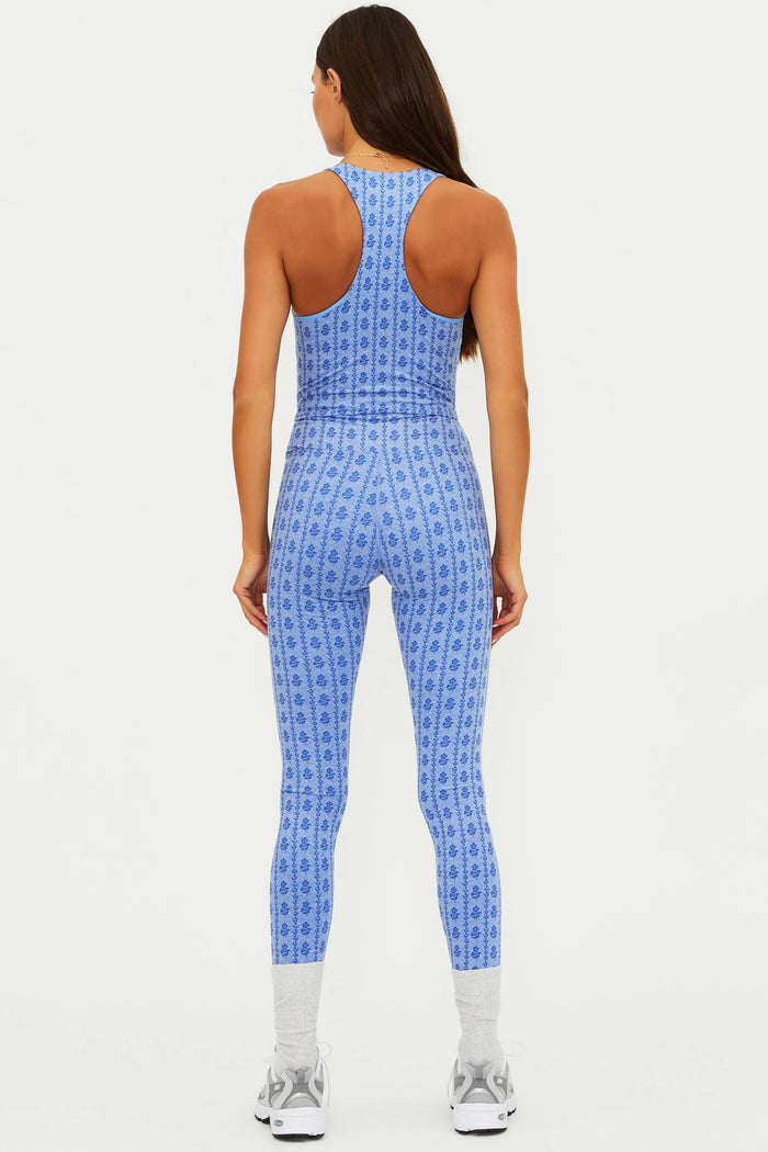 Woman wearing a blue patterned jumpsuit on a white background