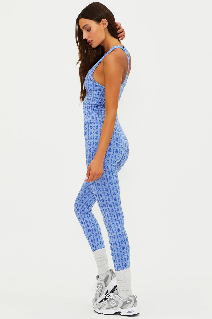 Woman wearing a blue patterned jumpsuit on a white background