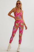 Woman wearing a pink floral sports bra and leggings set on a white background