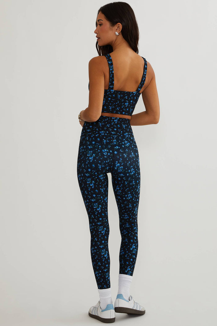 Woman wearing black leggings with blue floral.