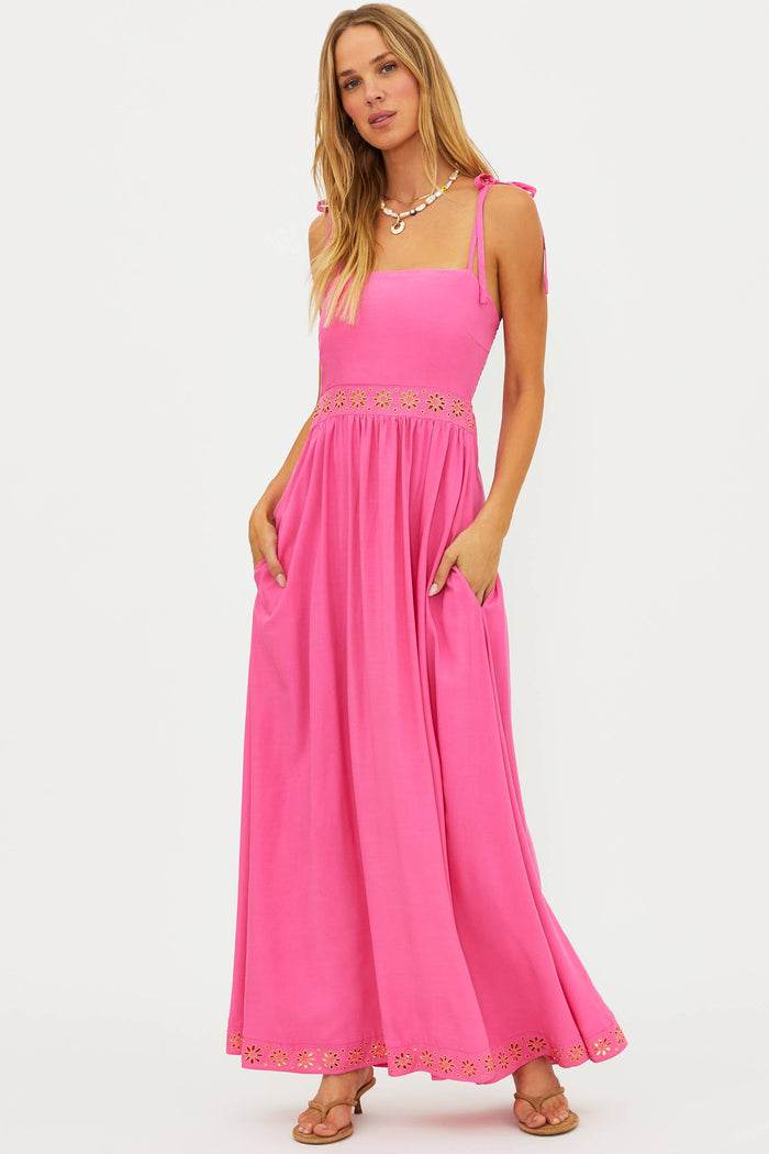 Woman wearing a pink dress with lace details on a white background