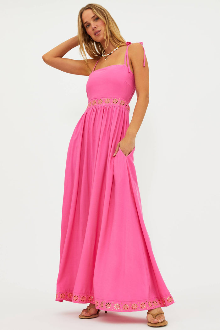 Woman wearing a pink dress with floral details on a white background