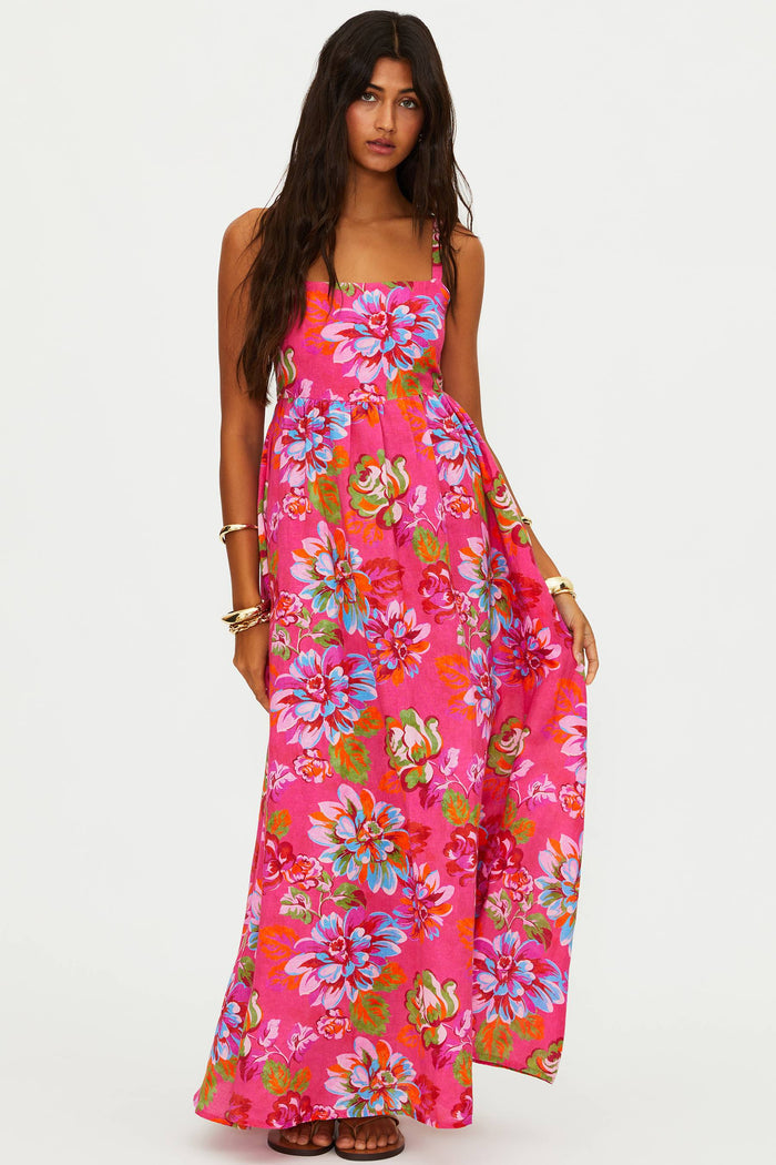 Woman wearing a pink floral maxi dress on a white background