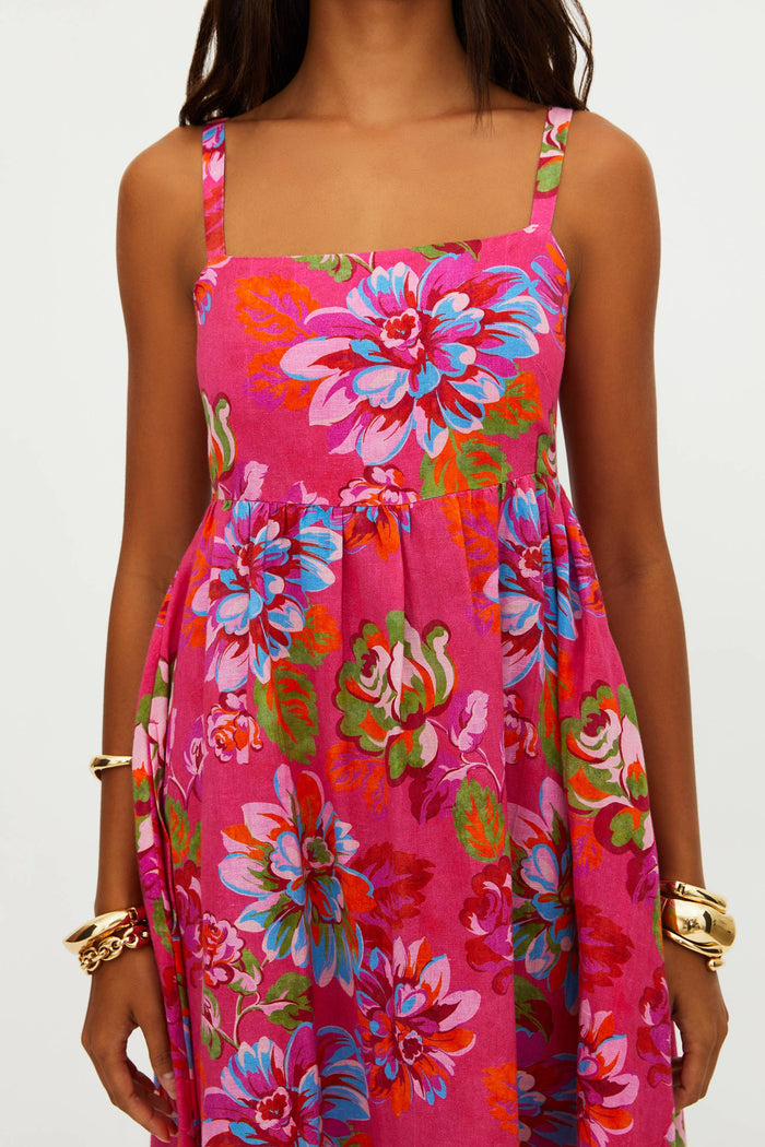 Woman wearing a vibrant pink floral dress on a white background