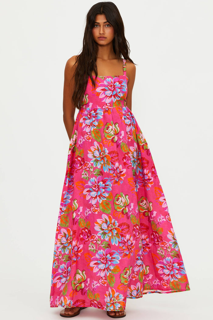 Woman wearing a vibrant floral dress on a white background