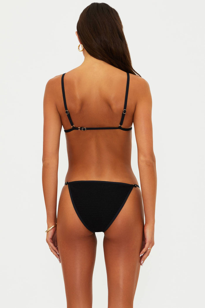 Black bikini worn by a model on a white background