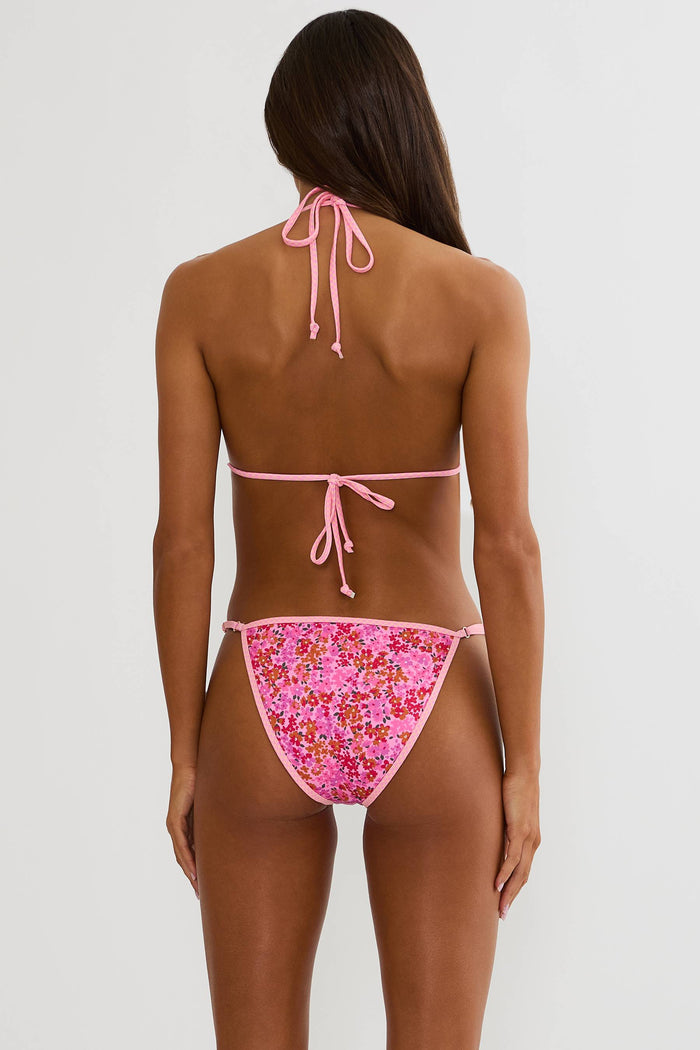 Woman wearing a pink bikini with floral pattern on a white background