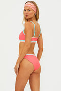 Woman wearing a pink and blue striped bikini with a white background