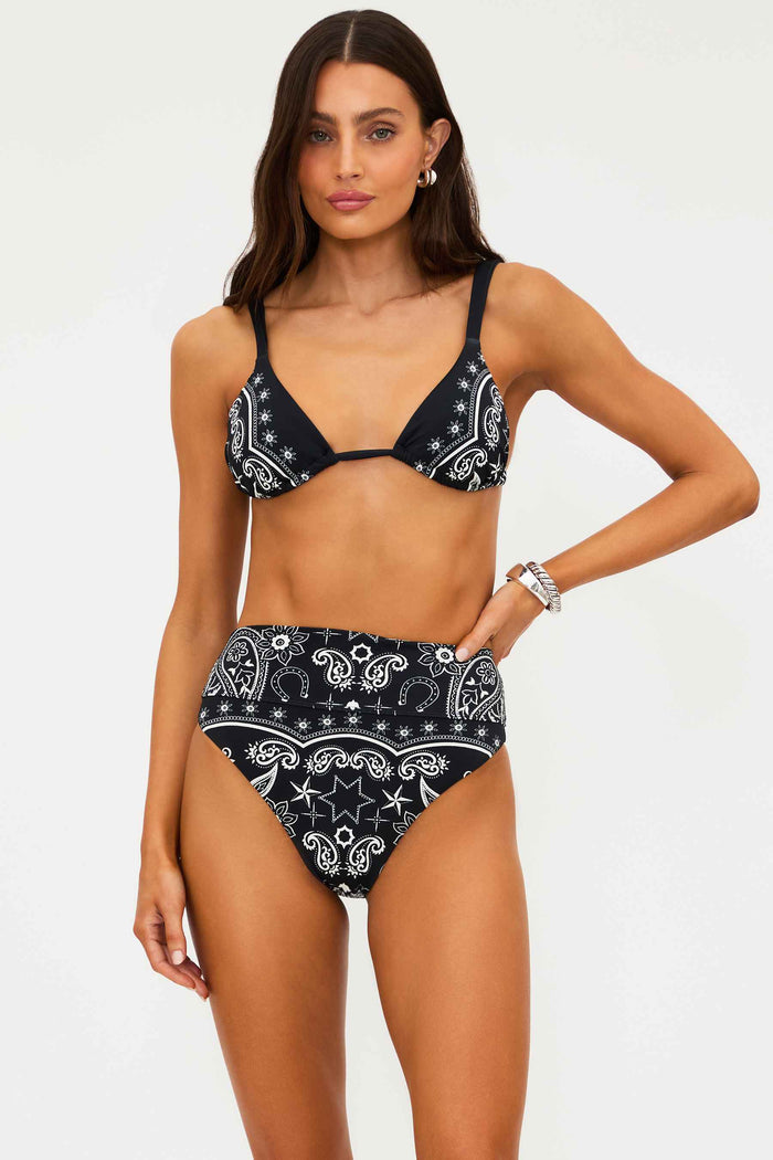Woman wearing a black and white patterned bikini on a white background