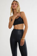 Woman wearing a shiny black workout bra top.
