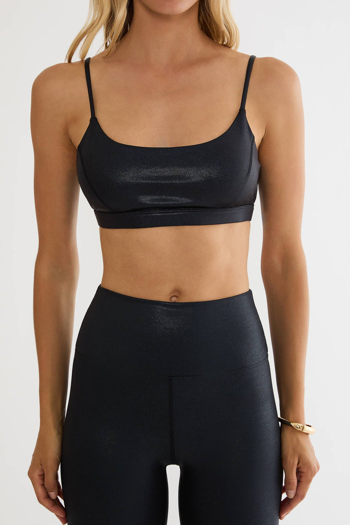 Woman wearing a shiny black workout bra top.