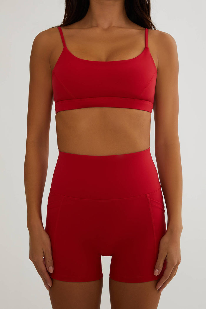 Red sports bra and shorts set on a plain background