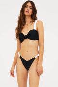 This image features the Sariah Top, a chic and supportive bandeau-inspired bikini top in a striking black and white color scheme. The top is designed with molded cups for lift and shape, and it boasts thick, ruched straps that ensure a secure fit.