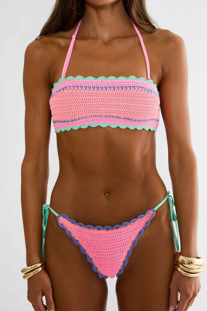 Woman wearing a colorful crochet bikini against a white background