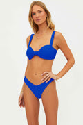 Woman wearing a blue bikini against a white background