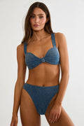 Woman wearing a blue denim bikini against a white background