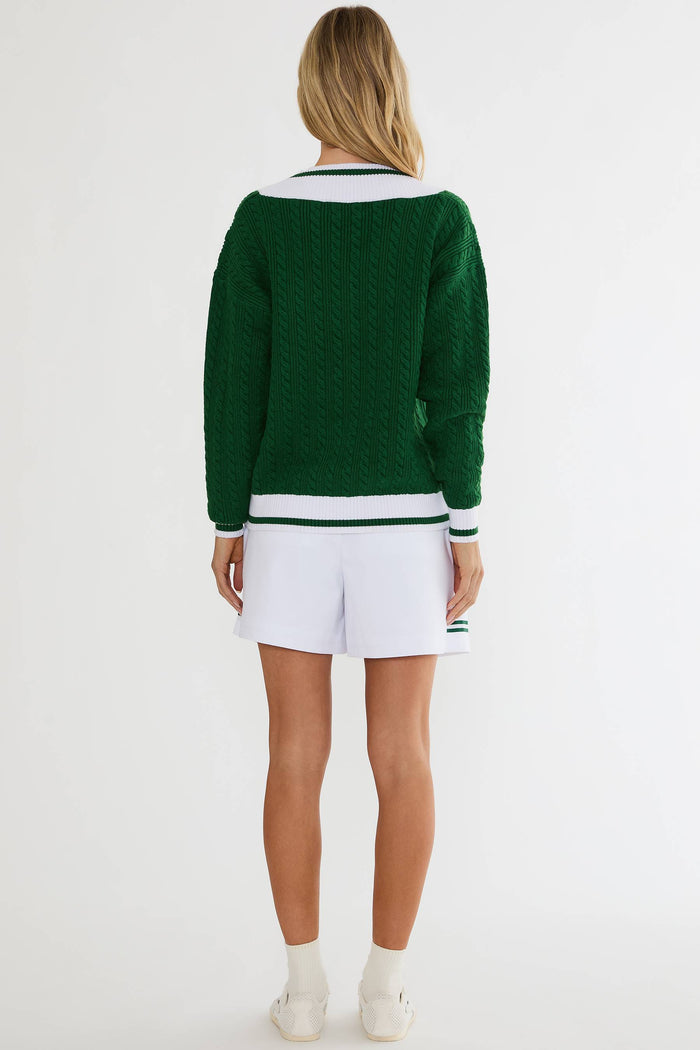Person wearing a green sweater with white shorts on a white background