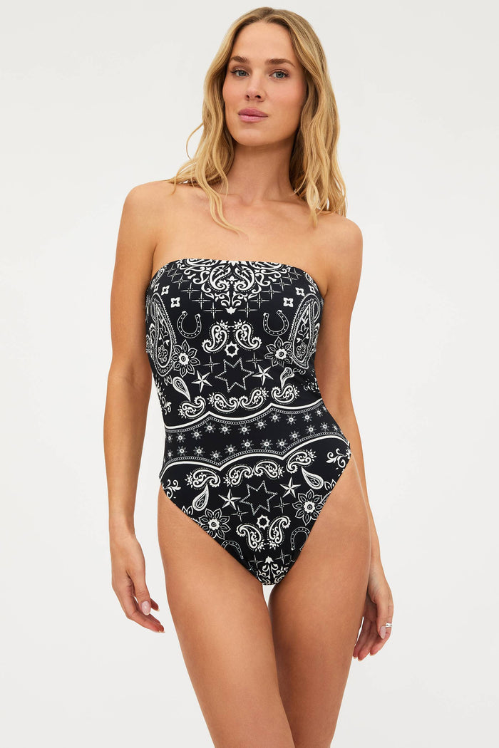 Woman wearing a black and white patterned strapless swimsuit on a white background