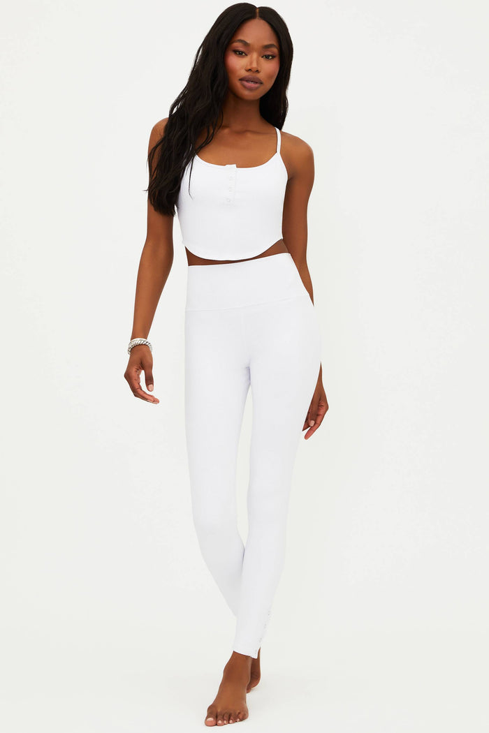 A model wearing white full-length leggings with no visible footwear, against a white background.