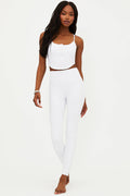 A model wearing white full-length leggings with no visible footwear, against a white background.