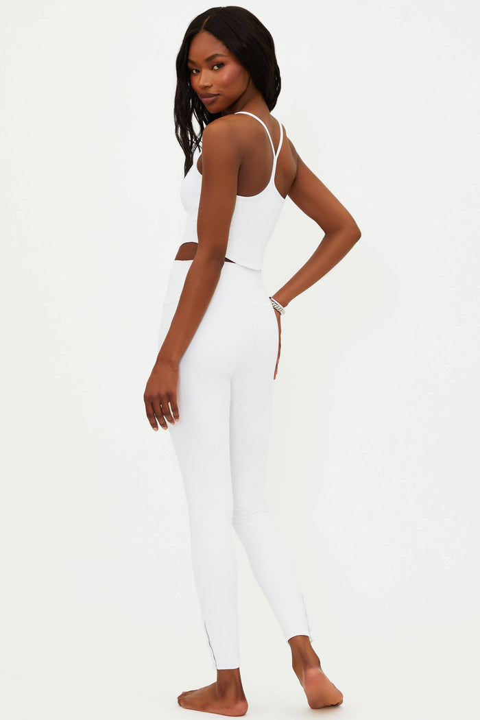 A model wearing white full-length leggings with no visible footwear, against a white background.