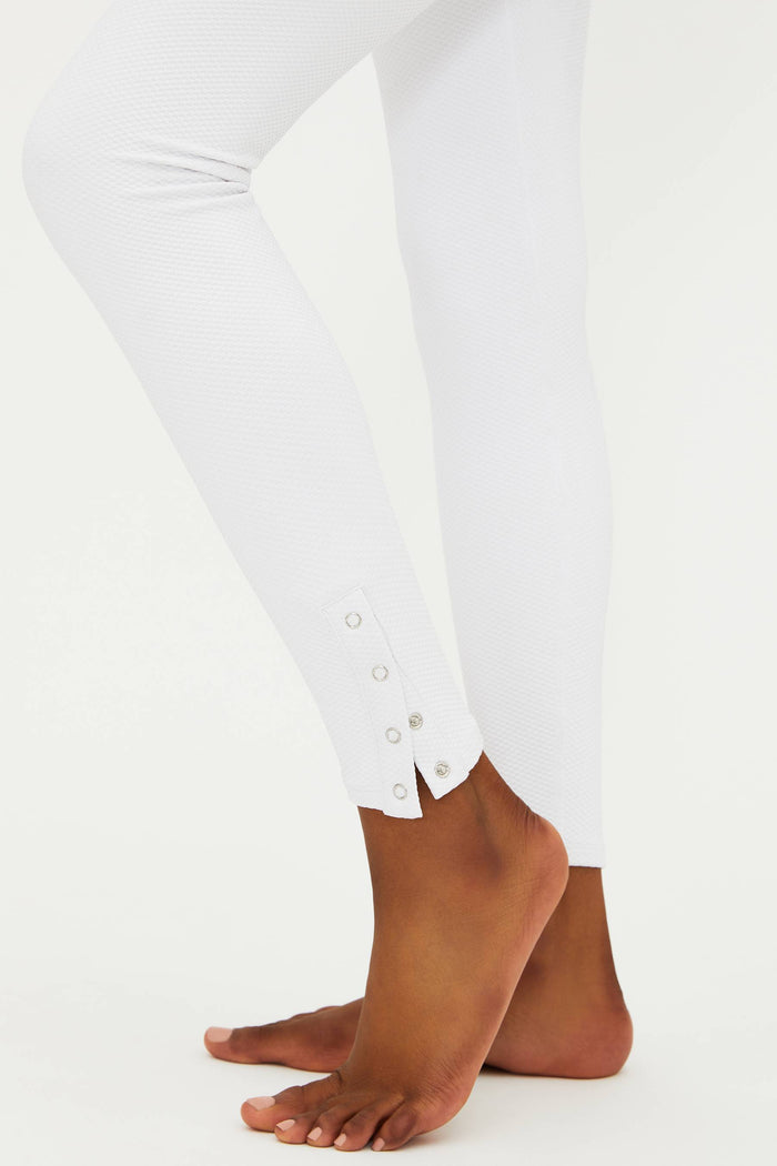 A model wearing white full-length leggings with no visible footwear, against a white background.
