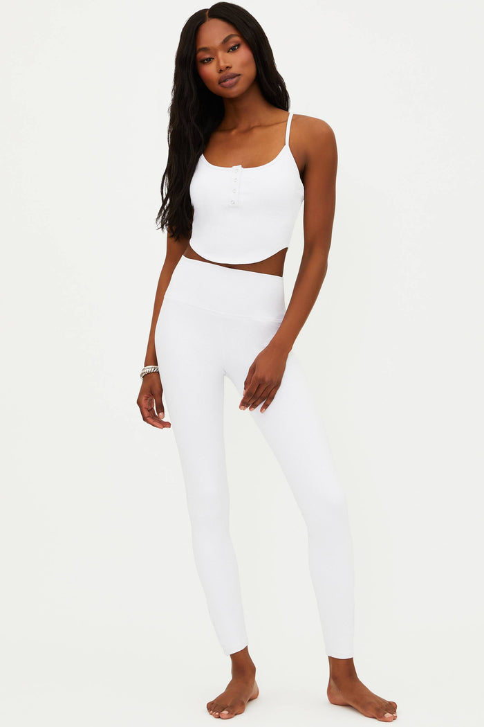 A model wearing white full-length leggings with no visible footwear, against a white background.