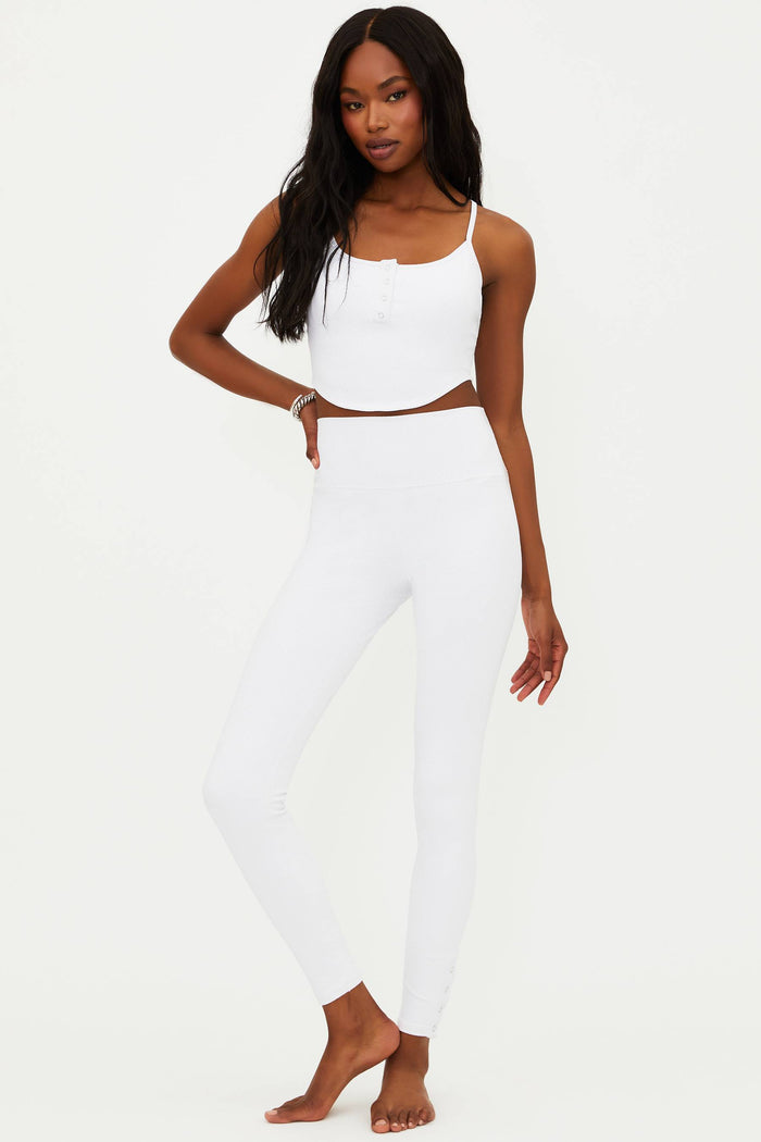 A model wearing white full-length leggings with no visible footwear, against a white background.