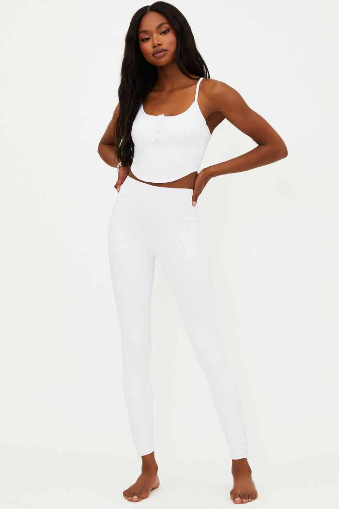 A model wearing white full-length leggings with no visible footwear, against a white background.