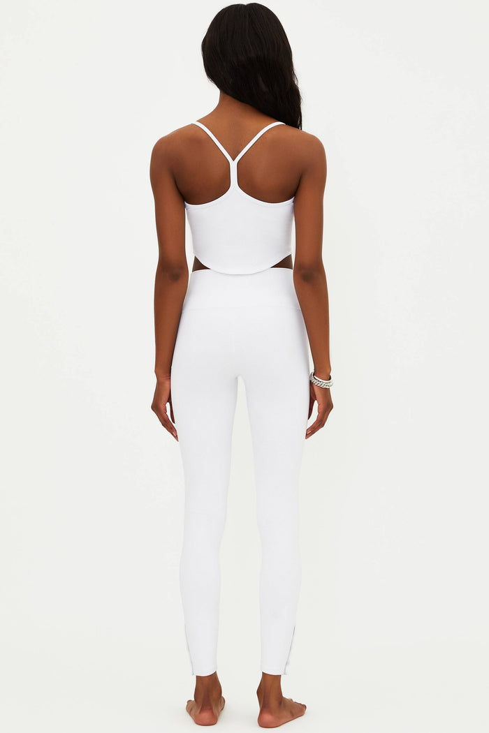 A model wearing white full-length leggings with no visible footwear, against a white background.